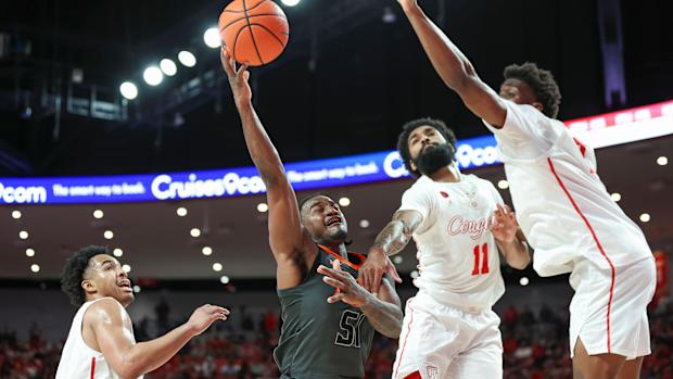 Feb 6, 2024; Houston, Texas, USA; Oklahoma State Cowboys guard John-Michael Wright (51) shoots the ball as Houston Cougars guard Damian Dunn (11) defends during the first half at Fertitta Center. Mandatory Credit: Troy Taormina-USA TODAY Sports